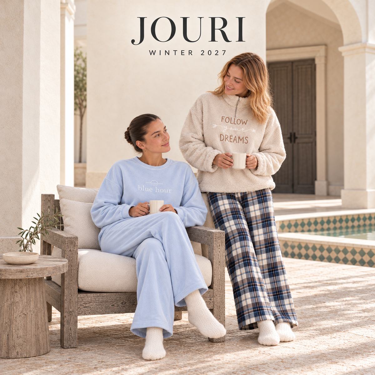 JOURI Winter 2027 — a quiet tea moment in blue and ivory homewear in the Jouri courtyard.
